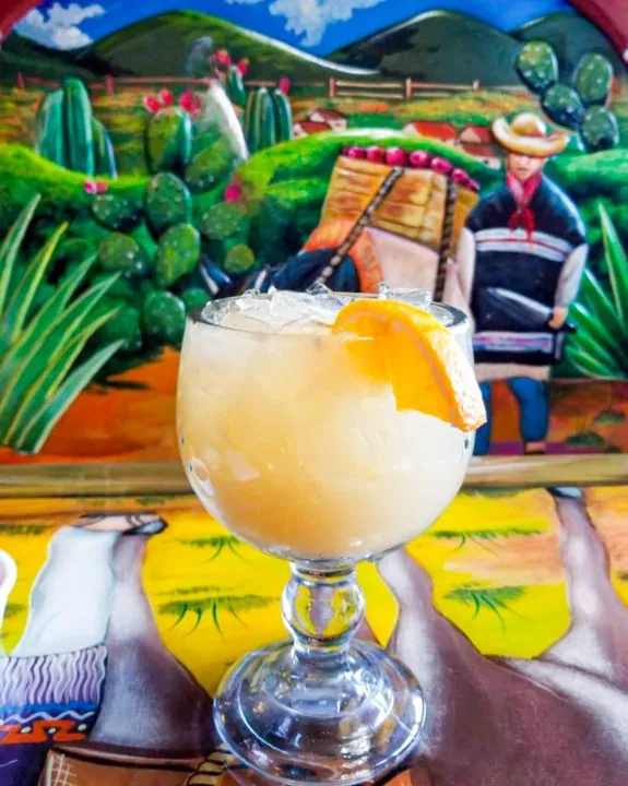 A margarita in front of a painted mural
