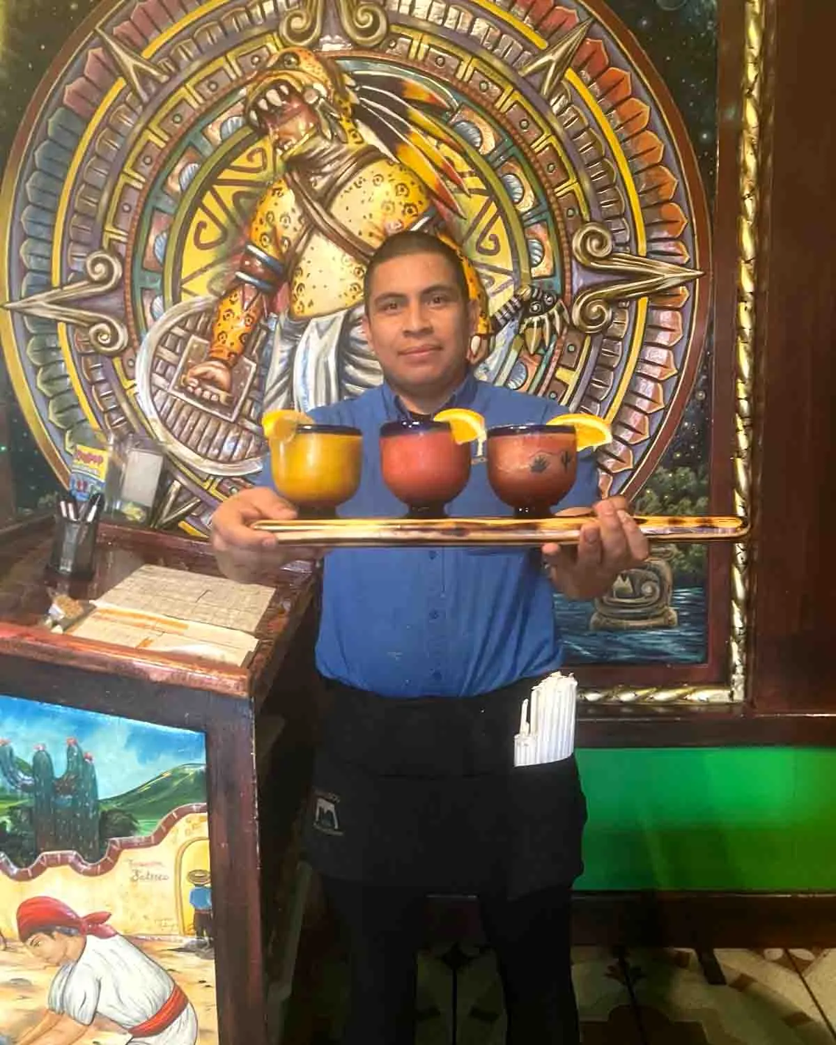 A waiter carrying a tray of margaritas